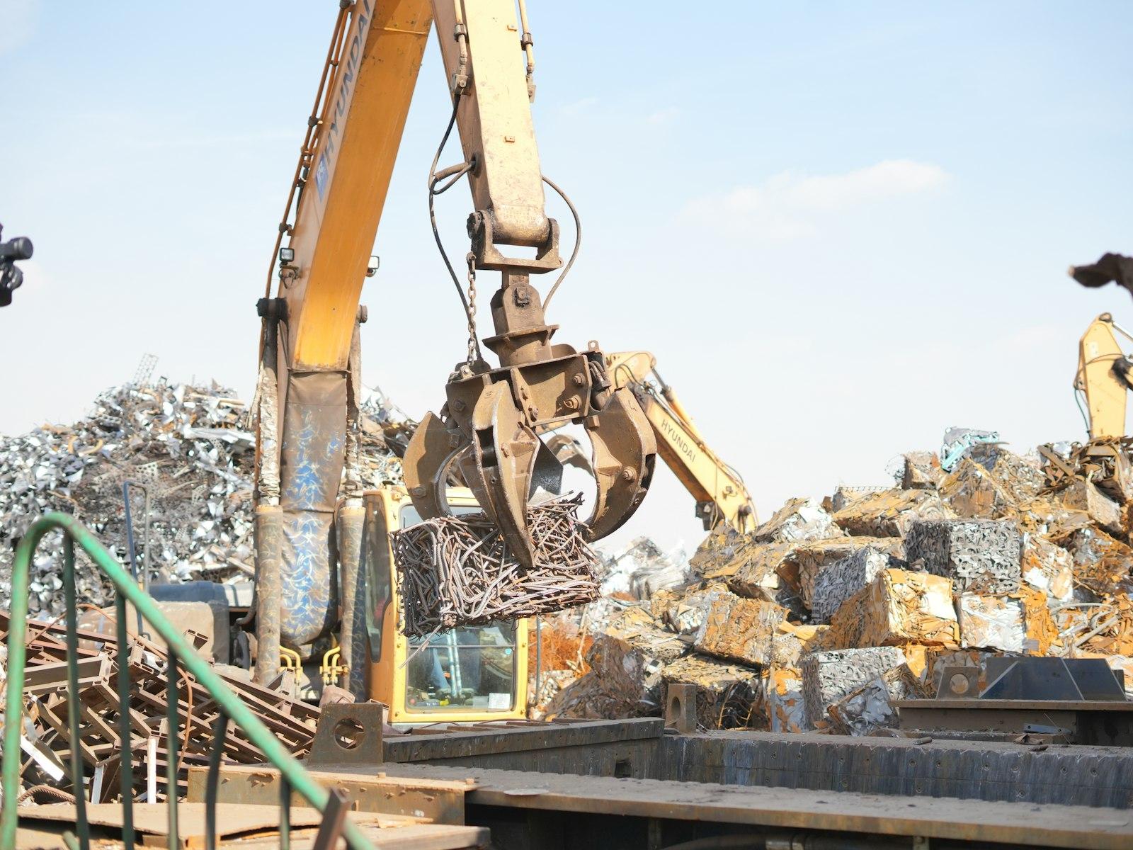 Excavator sorting a pile of scrap metal